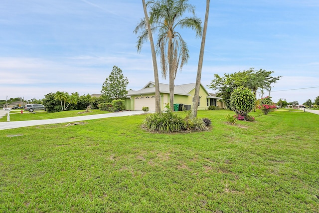654 SW Kayak Ave, Port Saint Lucie, FL 34953 - view of front facade with concrete driveway, a garage, a front lawn, and stucco siding