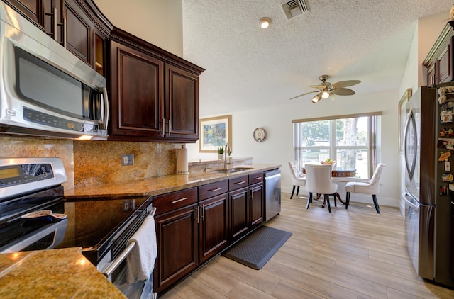4290 Camrose Ln, West Palm Beach, FL 33417 - kitchen featuring stainless steel appliances, tasteful backsplash, a textured ceiling, light wood-type flooring, and a ceiling fan