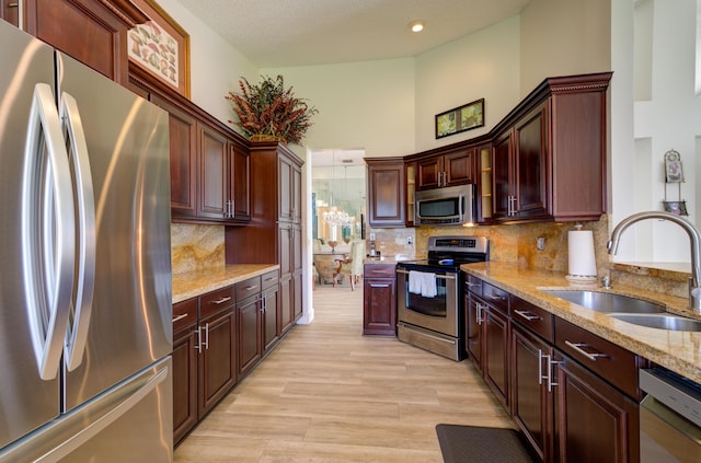 4290 Camrose Ln, West Palm Beach, FL 33417 - kitchen featuring stainless steel appliances, light stone counters, backsplash, a high ceiling, and light wood-style floors