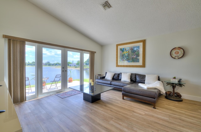 4290 Camrose Ln, West Palm Beach, FL 33417 - living area featuring a textured ceiling, vaulted ceiling, a water view, wood finished floors, and french doors