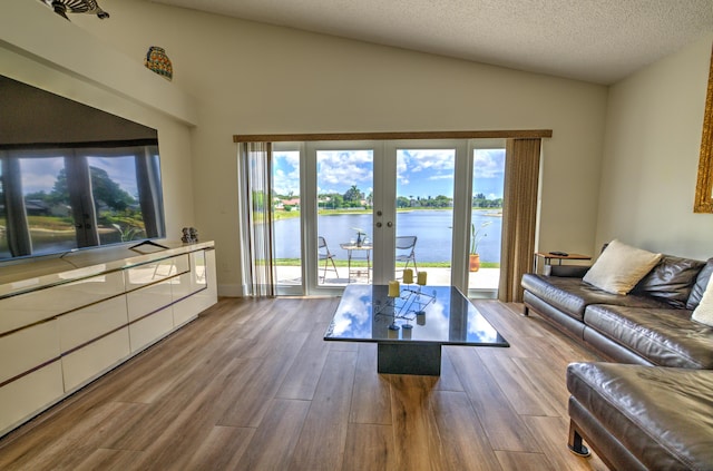 4290 Camrose Ln, West Palm Beach, FL 33417 - living room featuring french doors, lofted ceiling, wood finished floors, a water view, and a textured ceiling