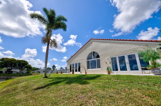 4290 Camrose Ln, West Palm Beach, FL 33417 - back of property with french doors, stucco siding, a lawn, and a tile roof
