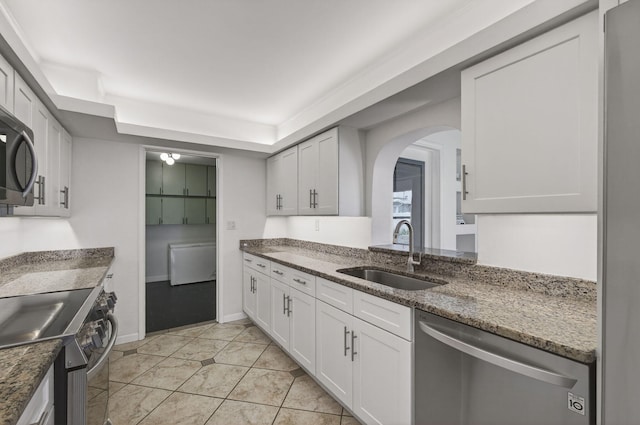 2476 S Florida Mango Rd, West Palm Beach, FL 33406 - kitchen with a sink, stainless steel appliances, arched walkways, white cabinets, and dark stone counters