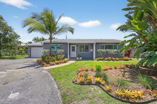 2476 S Florida Mango Rd, West Palm Beach, FL 33406 - ranch-style house featuring an attached garage, stucco siding, a front lawn, and driveway