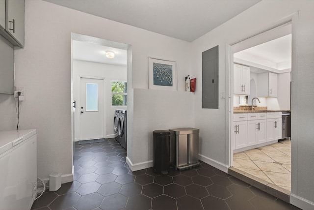2476 S Florida Mango Rd, West Palm Beach, FL 33406 - hallway featuring washer and clothes dryer, electric panel, dark tile patterned flooring, a sink, and baseboards