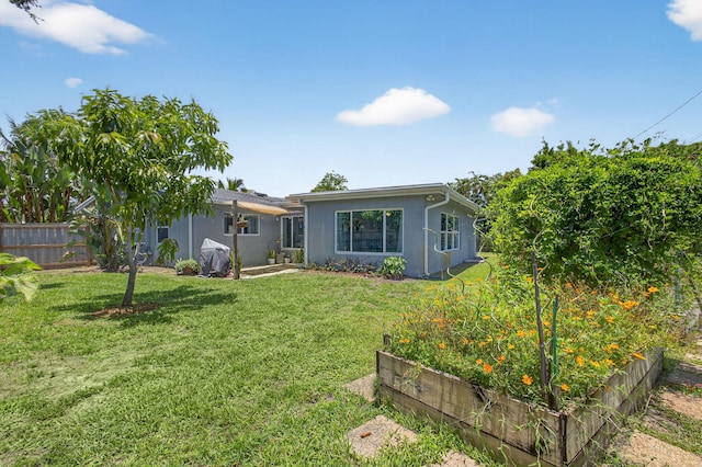 2476 S Florida Mango Rd, West Palm Beach, FL 33406 - back of property with a vegetable garden and stucco siding