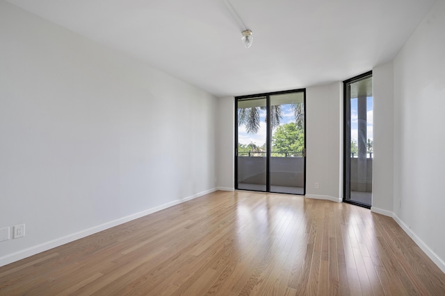 1401 S Ocean Blvd Unit 305, Boca Raton, FL 33432 - empty room with wood finished floors, baseboards, and a wall of windows
