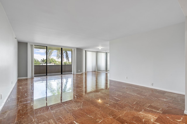 1401 S Ocean Blvd Unit 305, Boca Raton, FL 33432 - empty room with marble tiled flooring, baseboards, and floor to ceiling windows