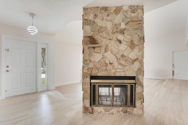 13655 N 68th St N, West Palm Beach, FL 33412 - entrance foyer with vaulted ceiling, wood finished floors, a textured ceiling, and a stone fireplace
