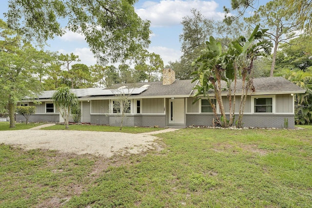 13655 N 68th St N, West Palm Beach, FL 33412 - single story home featuring board and batten siding, brick siding, a front lawn, and a chimney