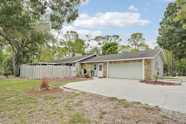 13655 N 68th St N, West Palm Beach, FL 33412 - view of front facade featuring concrete driveway, stone siding, and an attached garage