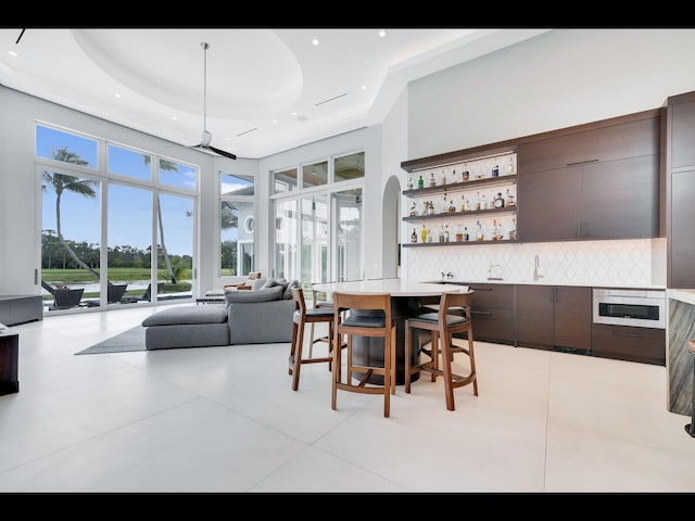 12990 Marsh Lndg, Palm Beach Gardens, FL 33418 - dining room featuring a raised ceiling, bar area, recessed lighting, and a high ceiling
