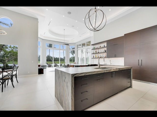 12990 Marsh Lndg, Palm Beach Gardens, FL 33418 - kitchen featuring modern cabinets, a tray ceiling, a spacious island, plenty of natural light, and recessed lighting