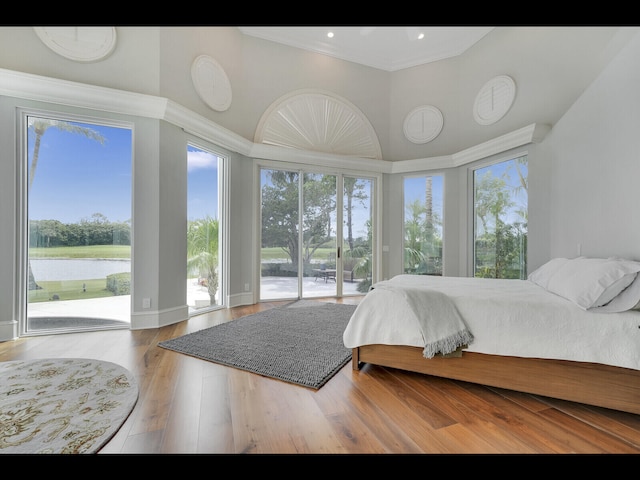 12990 Marsh Lndg, Palm Beach Gardens, FL 33418 - bedroom featuring access to outside, multiple windows, crown molding, a water view, and wood finished floors