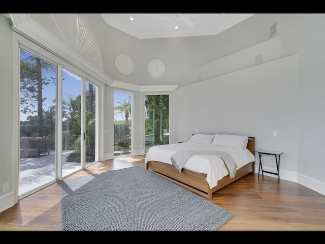 12990 Marsh Lndg, Palm Beach Gardens, FL 33418 - bedroom with access to exterior, a towering ceiling, wood finished floors, crown molding, and recessed lighting