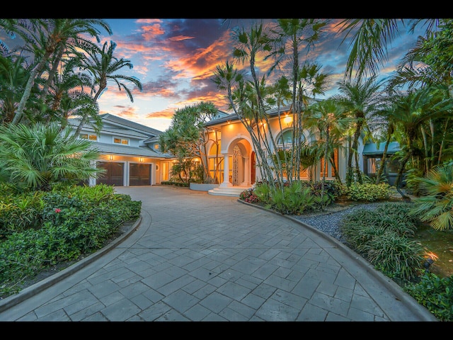 12990 Marsh Lndg, Palm Beach Gardens, FL 33418 - mediterranean / spanish home with curved driveway, stucco siding, and a garage