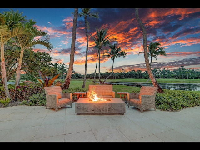 12990 Marsh Lndg, Palm Beach Gardens, FL 33418 - patio terrace at dusk featuring an outdoor fire pit, a patio area, and a water view