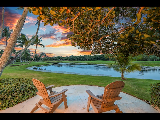 12990 Marsh Lndg, Palm Beach Gardens, FL 33418 - patio terrace at dusk with a water view, a lawn, and a patio area