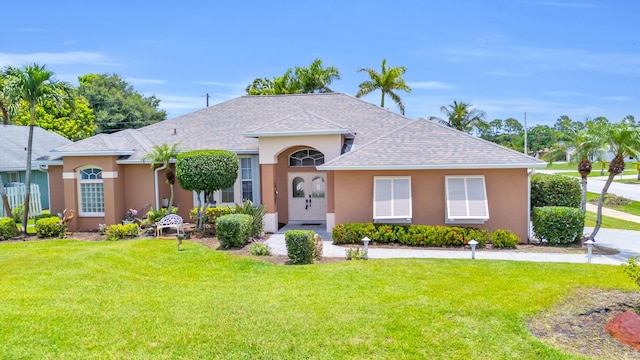 3592 SW Rosser Blvd, Port Saint Lucie, FL 34953 - view of front of home with a front lawn, stucco siding, and a shingled roof