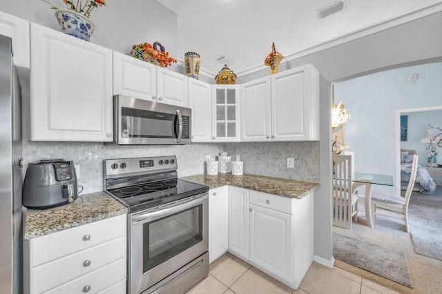 3592 SW Rosser Blvd, Port Saint Lucie, FL 34953 - kitchen with stainless steel appliances, light tile patterned floors, light stone countertops, and white cabinetry