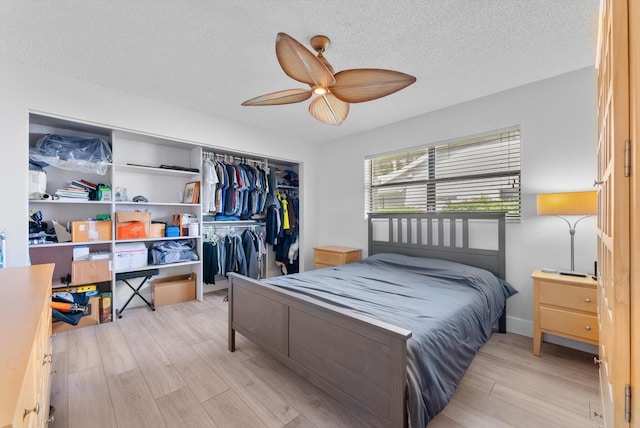 3099 NW 28th Ter, Boca Raton, FL 33434 - bedroom with light wood-style floors, a closet, a textured ceiling, and a ceiling fan