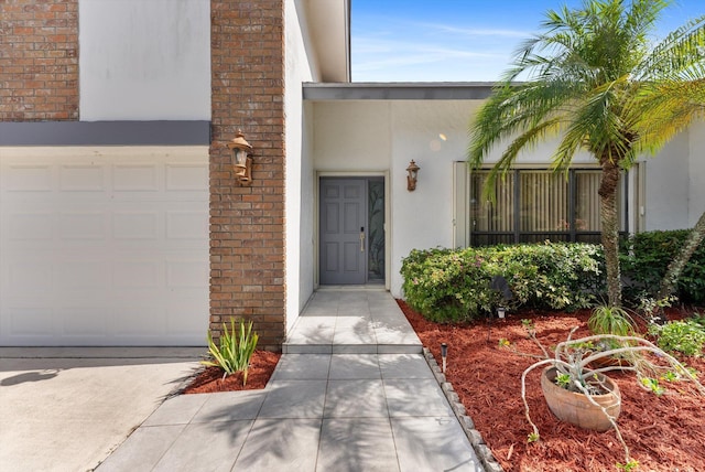 3099 NW 28th Ter, Boca Raton, FL 33434 - view of exterior entry featuring stucco siding, a garage, and brick siding