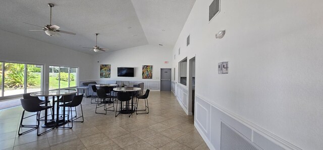 5255 Monterey Cir Unit G, Delray Beach, FL 33484 - dining area with a ceiling fan, high vaulted ceiling, a decorative wall, a wainscoted wall, and light tile patterned floors