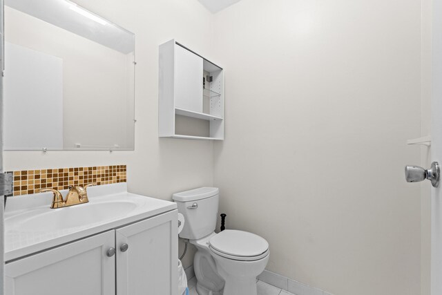 366 Saxony H, Delray Beach, FL 33446 - bathroom featuring decorative backsplash, vanity, toilet, tile patterned flooring, and baseboards