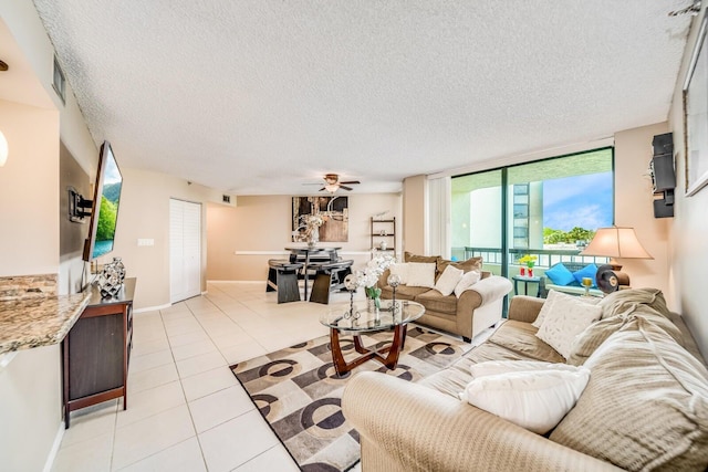 6372 La Costa Dr Unit 306, Boca Raton, FL 33433 - living area featuring a textured ceiling, light tile patterned flooring, ceiling fan, and baseboards