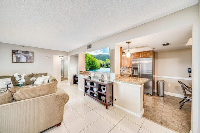 6372 La Costa Dr Unit 306, Boca Raton, FL 33433 - living room featuring light tile patterned floors, a textured ceiling, and baseboards