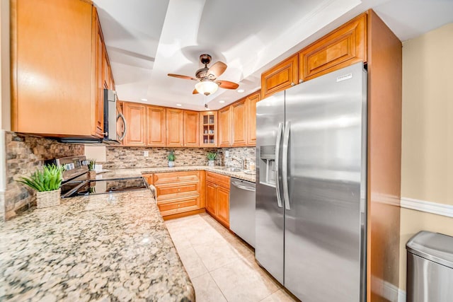 6372 La Costa Dr Unit 306, Boca Raton, FL 33433 - kitchen featuring stainless steel appliances, backsplash, a sink, a ceiling fan, and light stone countertops
