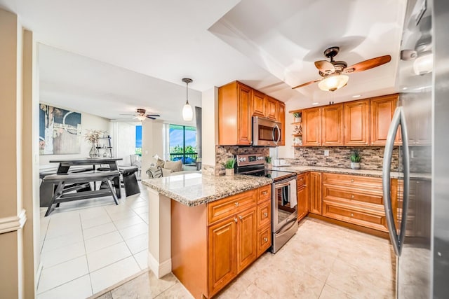 6372 La Costa Dr Unit 306, Boca Raton, FL 33433 - kitchen featuring stainless steel appliances, a ceiling fan, backsplash, light stone countertops, and brown cabinets