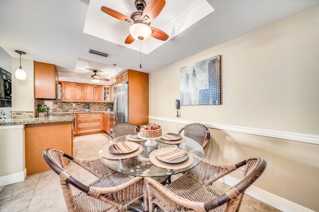 6372 La Costa Dr Unit 306, Boca Raton, FL 33433 - dining room featuring a ceiling fan, a tray ceiling, light tile patterned floors, and baseboards