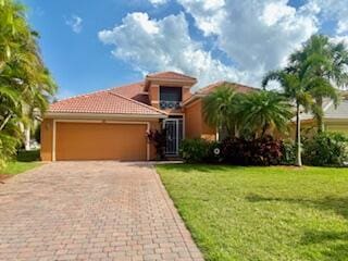344 NW Stratford Ln, Port Saint Lucie, FL 34983 - view of front facade with an attached garage, decorative driveway, a front yard, and a tile roof