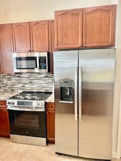 344 NW Stratford Ln, Port Saint Lucie, FL 34983 - kitchen featuring stainless steel appliances and backsplash