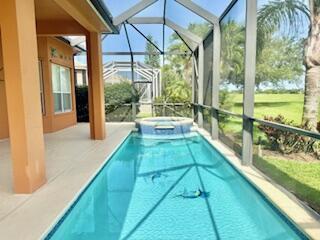 344 NW Stratford Ln, Port Saint Lucie, FL 34983 - view of swimming pool featuring a lanai, a patio, and a pool with connected hot tub