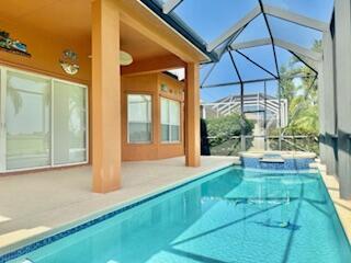 344 NW Stratford Ln, Port Saint Lucie, FL 34983 - view of pool featuring a patio area, glass enclosure, and a pool with connected hot tub