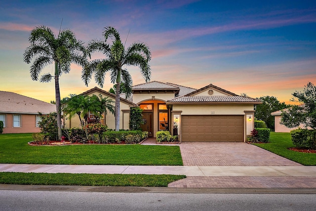 1415 SE Legacy Cove Cir, Stuart, FL 34997 - mediterranean / spanish-style home featuring decorative driveway, stucco siding, a garage, and a front lawn