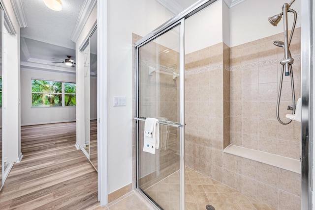 1415 SE Legacy Cove Cir, Stuart, FL 34997 - full bath with a stall shower, a ceiling fan, wood finished floors, a textured ceiling, and ornamental molding