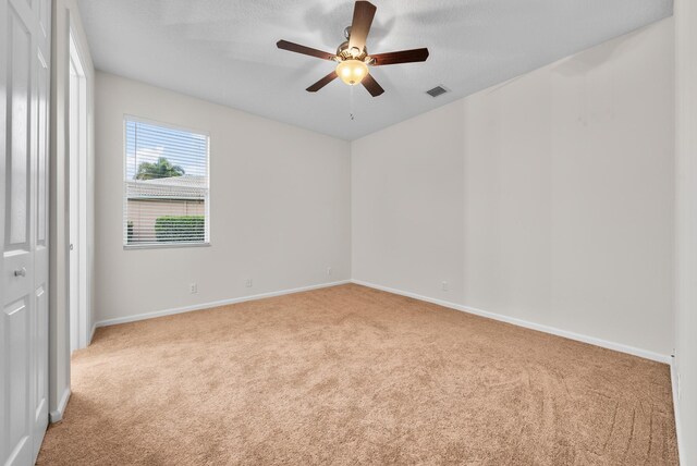 1415 SE Legacy Cove Cir, Stuart, FL 34997 - empty room with carpet floors, a ceiling fan, and a textured ceiling