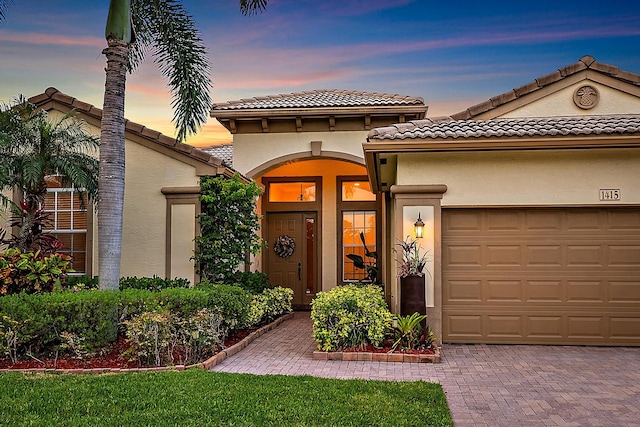 1415 SE Legacy Cove Cir, Stuart, FL 34997 - mediterranean / spanish-style home with an attached garage, stucco siding, decorative driveway, and a tiled roof