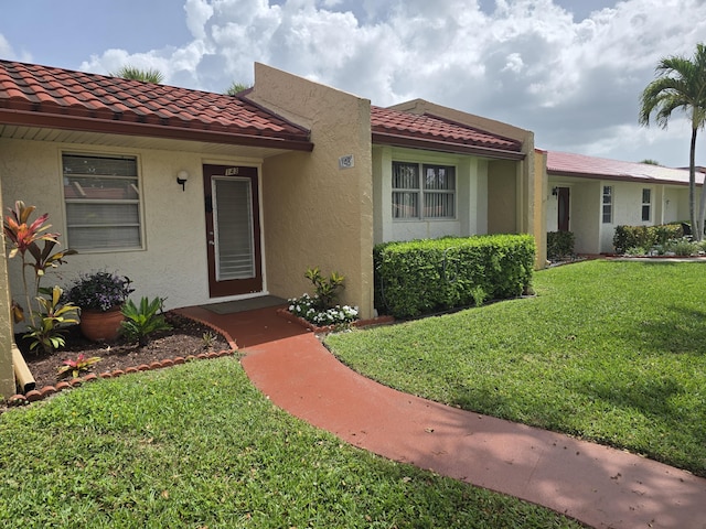 143 Lake Barbara Dr, West Palm Beach, FL 33411 - view of front facade with a front lawn, stucco siding, and a tiled roof