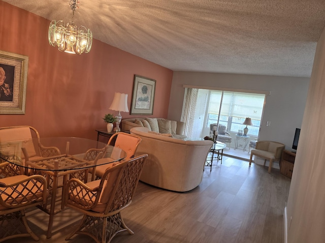 143 Lake Barbara Dr, West Palm Beach, FL 33411 - dining space with a textured ceiling, wood finished floors, and a chandelier