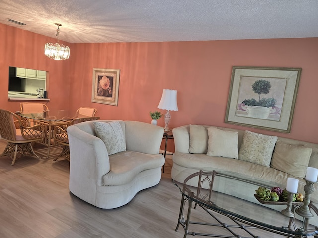 143 Lake Barbara Dr, West Palm Beach, FL 33411 - living room with a chandelier, wood finished floors, and a textured ceiling