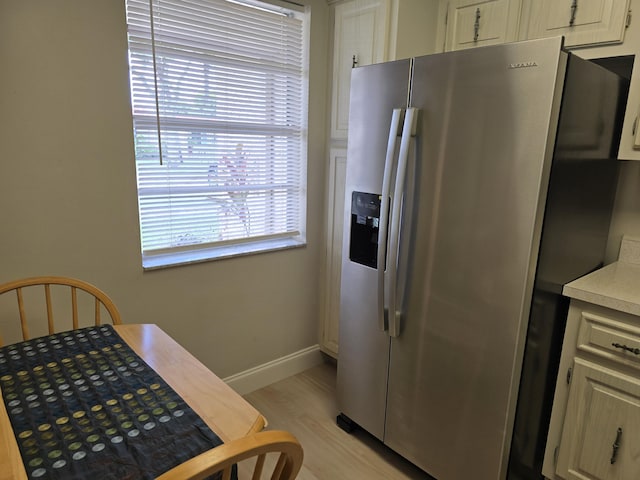 143 Lake Barbara Dr, West Palm Beach, FL 33411 - kitchen featuring stainless steel fridge with ice dispenser, light countertops, light wood-style flooring, and baseboards