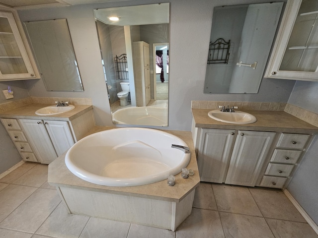 3817 SW Cheribon St, Port Saint Lucie, FL 34953 - bathroom with two vanities, a bath, toilet, and tile patterned floors