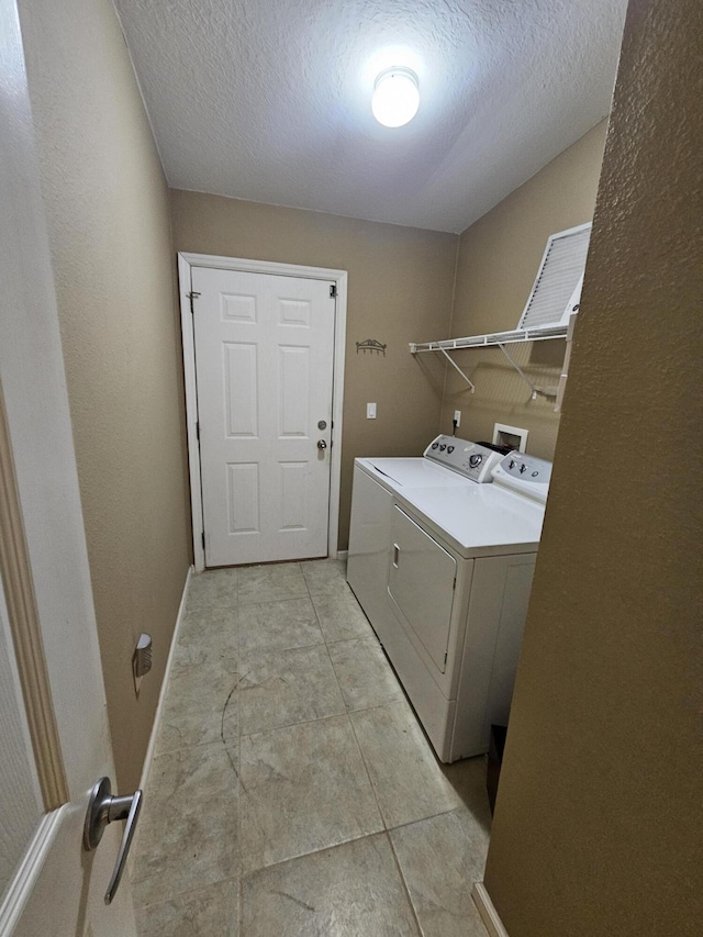 3817 SW Cheribon St, Port Saint Lucie, FL 34953 - washroom featuring washer and dryer, a textured ceiling, and baseboards