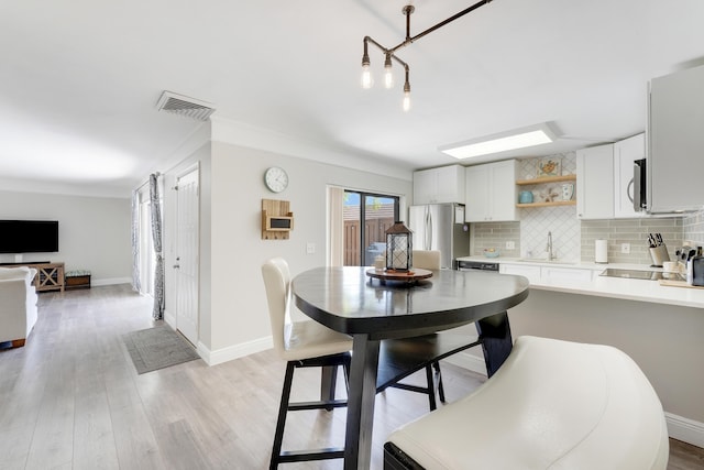 3900 County Line Rd Unit 4C, Tequesta, FL 33469 - dining space featuring light wood-style floors, baseboards, and crown molding