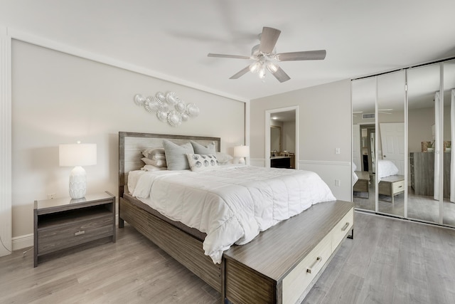 3900 County Line Rd Unit 4C, Tequesta, FL 33469 - bedroom with light wood-style flooring, ceiling fan, and ensuite bath