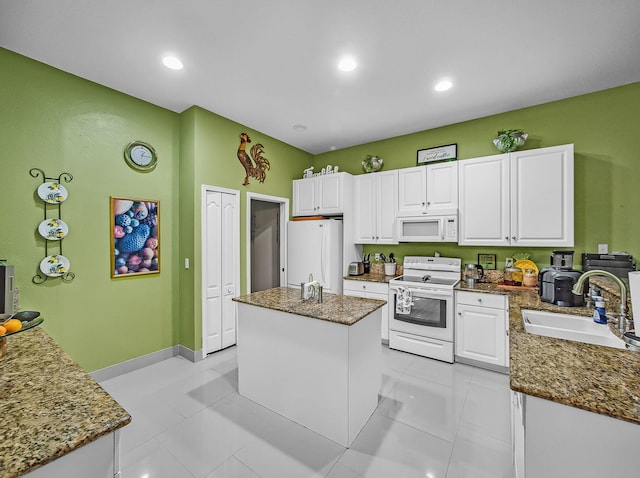 1081 SW Jacqueline Ave, Port Saint Lucie, FL 34953 - kitchen with white appliances, white cabinets, a kitchen island, dark stone countertops, and recessed lighting